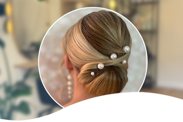 Elegante Brautfrisur mit hochgestecktem Haar und Perlennadeln