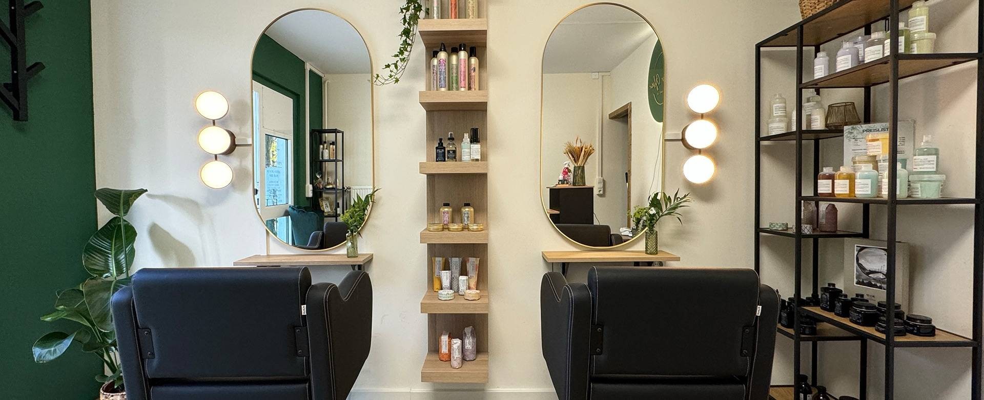 Salon von Studio Glow mit Stylingplätzen, Messingspiegeln und offenen Regalen